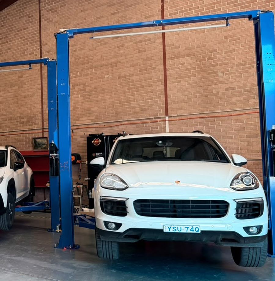 SUV on the two-post hoist in the service bay